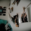 Photographs are hanging by clothespins from twine in a dorm room.